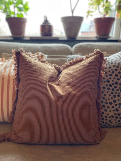 Randigt kuddfodral i varm mandelton med fransar 50x50 cm